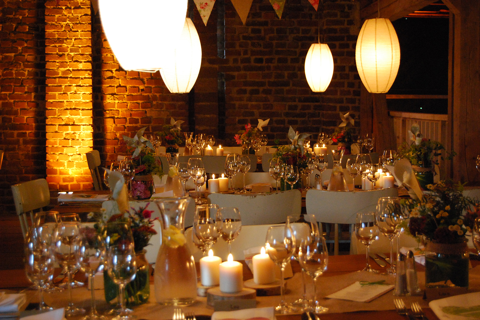 Gedeckte Tische und Kerzen für Feier in Partyscheune